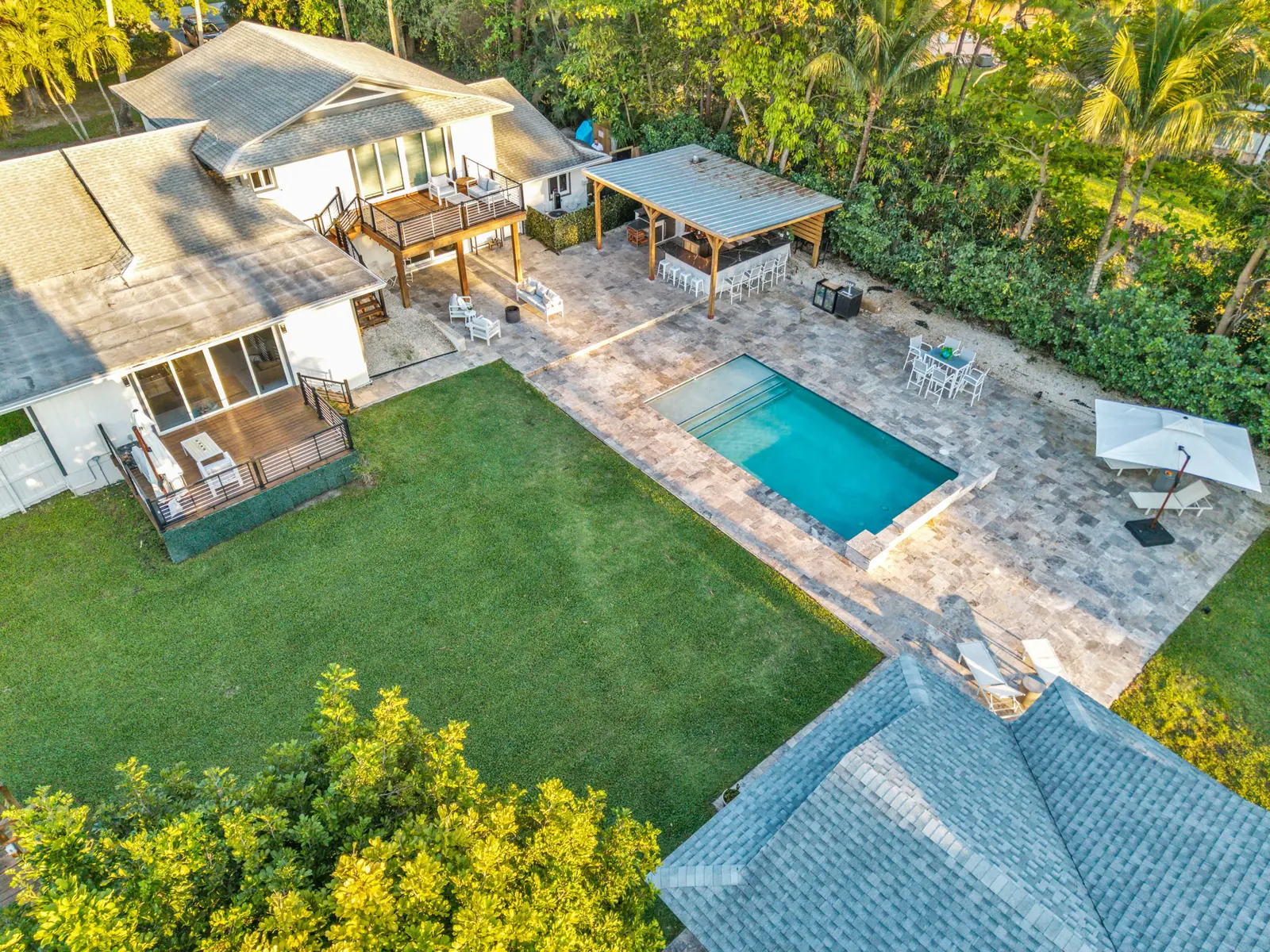 Golden-hour aerial of a pool and lawn in Delray Beach