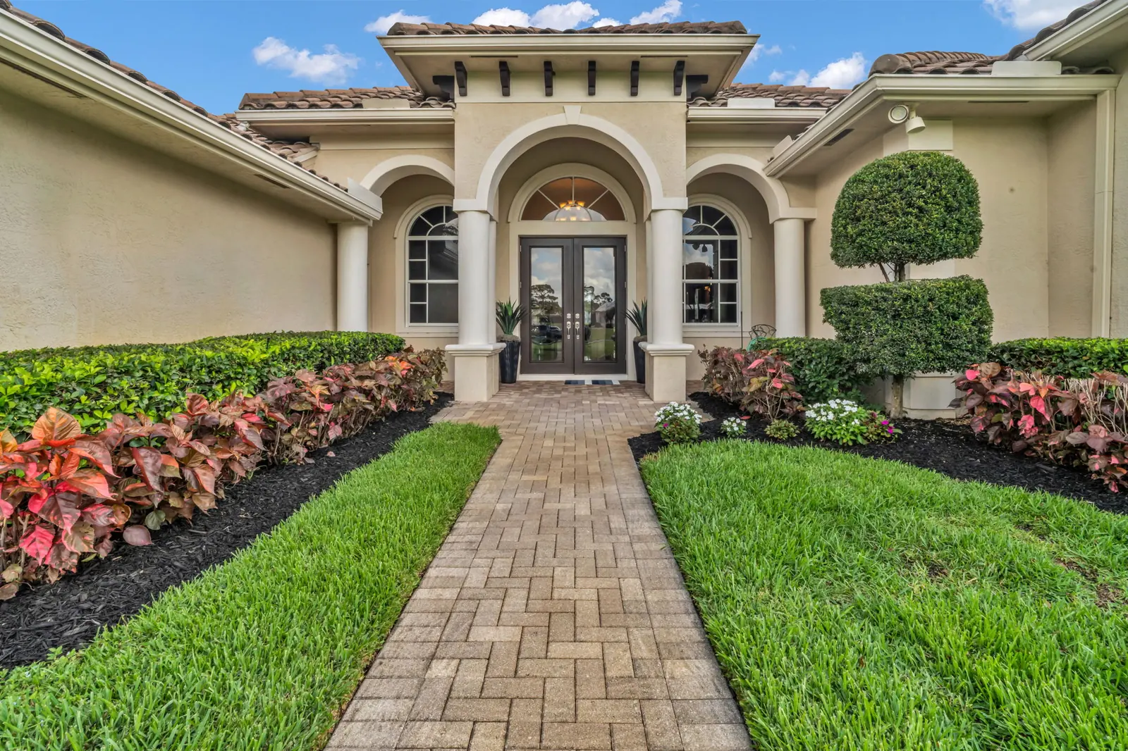 Front entry and landscaped walk of a Palm City home